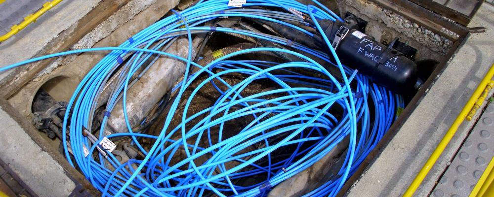Fiberoptisk kabel och två fibersvetsare i en Telstra-brunn/kanal. Foto: Symbolbild. Wikipedia Commons Lic. Kredit: Bidgee