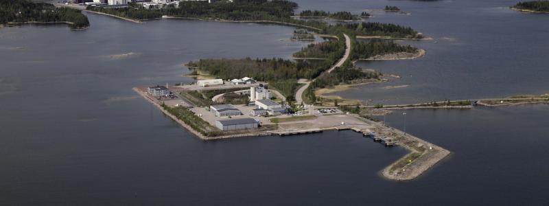 I Forsmark i Östhammars kommun ligger SKB:s anläggning SFR – Slutförvaret för kortlivat radioaktivt avfall. Det radioaktiva avfall som förvaras i SFR är låg- och medelaktivt. Det betyder att det till skillnad från använt kärnbränsle inte behöver kylas och att det är relativt kortlivat. SFR ligger 60 meter under Östersjöns botten och består av fyra 160 meter långa bergssalar och ett bergrum med en 50 meter hög betongsilo för det medelaktiva avfallet. Två parallella kilometerlånga tillfartstunnlar förbinder anläggningen med markytan. Vy från öst. Copyright: SKB. Fotograf: Lasse Modin