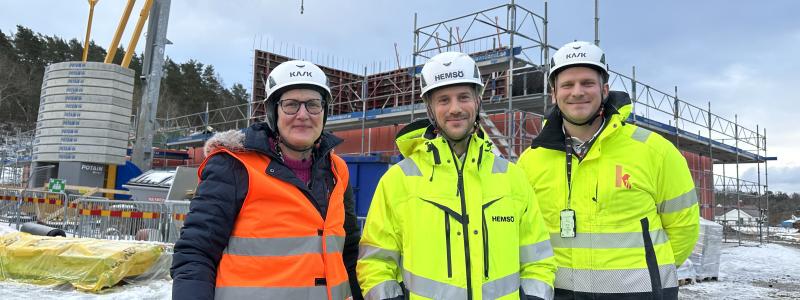Birgitta Andersson, projektledare samhällsbyggnad, Tobias Lagerwall, projektchef Hemsö och Simon Hagman, projektchef K21 framför bygget av Forshälla-Strands förskola i Råssbyn. Foto: Uddevalla kommun