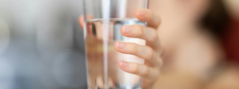 Hand som håller i ett glas vatten. Foto: engin akyurt / Unsplash