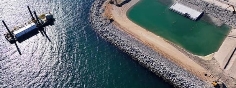 Den norra portalområdet har översvämmats så att den första tunneldelen nu ligger i vattnet. Den framförliggande vallen kommer härnäst att monteras ned. De övriga tunnelsektionerna kommer senare att anslutas till denna tunneldel. Foto: Femern A/S/Christian Huebner.