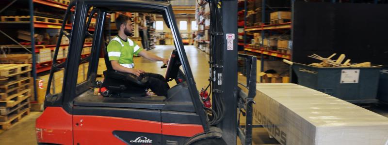 Truckförare som lyfter pall. Foto: Byggmaterialhandlarna