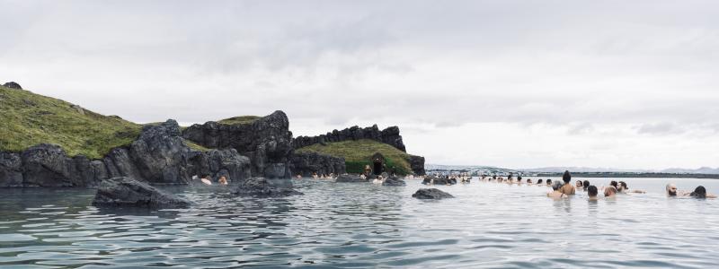 Sky Lagoon på Island. Turister som njuter av ett geotermiskt spa med uppvärmt vatten under en kall dag. Av: Renata Tyburczy