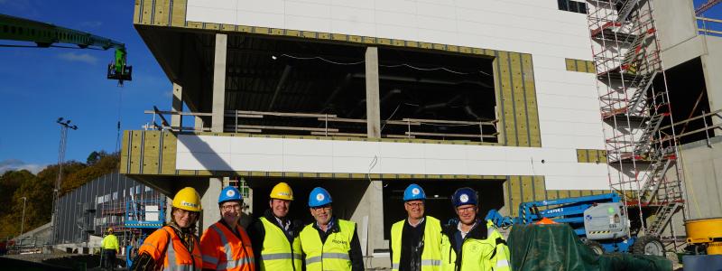 Nu börjar Rimnersbadet i Uddevalla ta form. Maria Jacobsson, Monica Bang Lindberg, Ingemar Samuelsson, Per Bäckström och Christer Hasslebäck med projektledare Anders Emilsson framför bygget av Uddevallas nya simhall. Foto: Uddevalla kommun