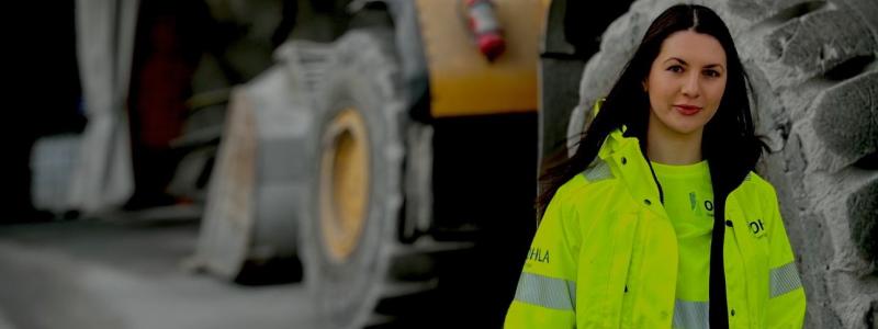 Medarbetare i skyddskläder vid tung anläggningsutrustning i projektet vid Gullmarsplan. Bilden togs i en säker, avstängd miljö utan pågående arbete, där ordinarie skyddsutrustning tillfälligt togs av enbart för fotograferingen. Fotot lyfter OHLA Sveriges satsning på ökad jämställdhet och fler kvinnor i byggbranschen. Pressbild: OHLA