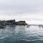 Sky Lagoon på Island. Turister som njuter av ett geotermiskt spa med uppvärmt vatten under en kall dag. Av: Renata Tyburczy