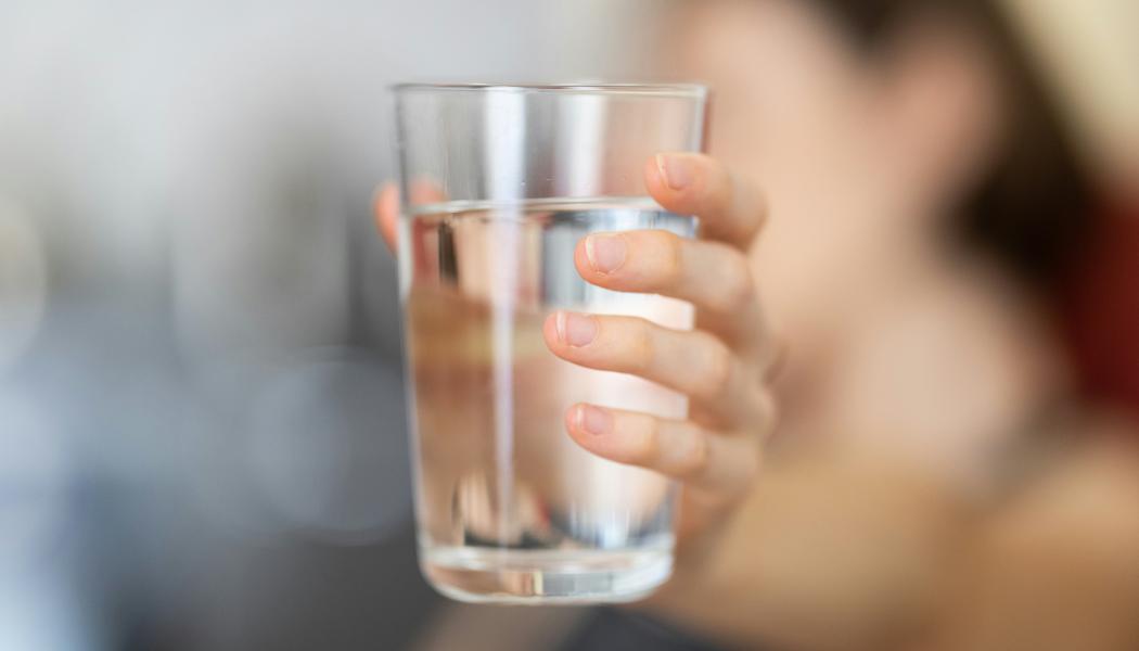 Hand som håller i ett glas vatten. Foto: engin akyurt / Unsplash