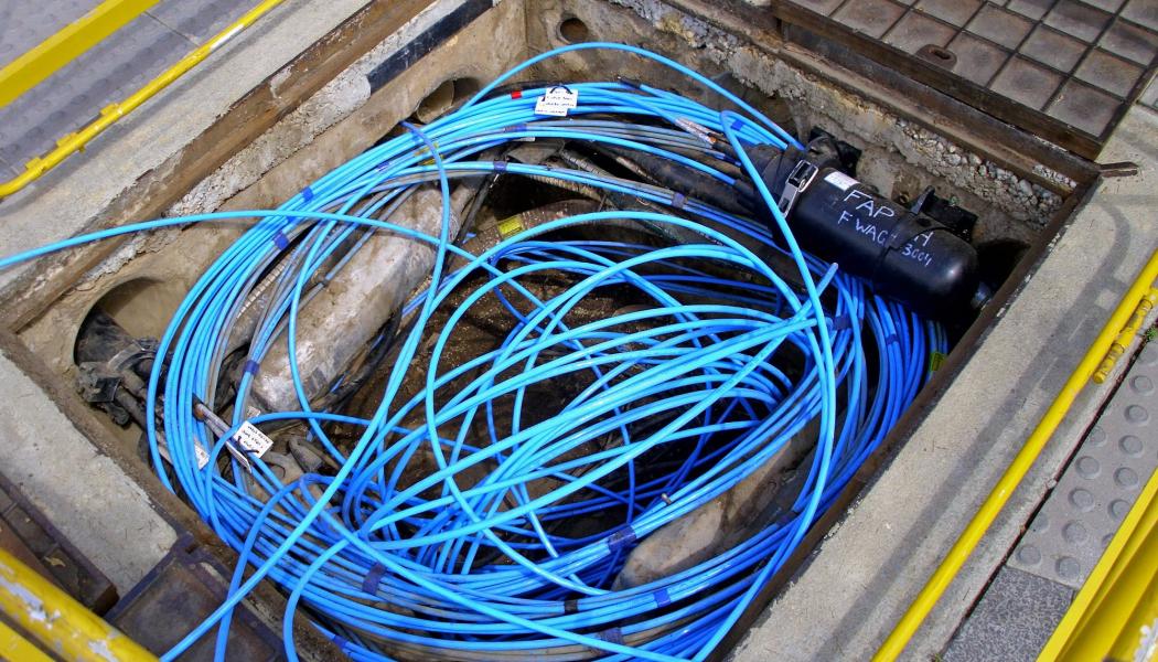 Fiberoptisk kabel och två fibersvetsare i en Telstra-brunn/kanal. Foto: Symbolbild. Wikipedia Commons Lic. Kredit: Bidgee