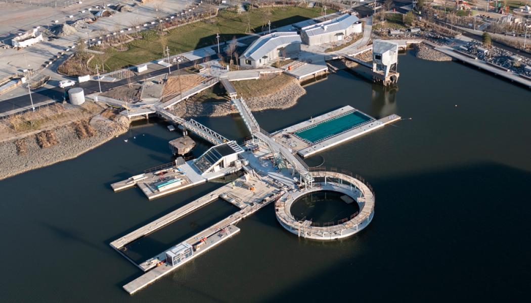 Hamnbadet i Jubileumsparken, Frihamnen 7 i Göteborg. Två naturvattenpooler och en sötvattenpool med naturlig rening, flytande ytan totalt ca 1008 m² och bassängerna sammanlagt ca 580 m². Befintliga pontoner och bassäng har återanvänts. Pontonerna är exceptionellt stora, gjutna och levererade på sänkbar pråm. Speciellt för hamnbadet är också diamantformade pontonen i mitten och den runda pontonen med hopptorn utanpå. Foto: Bluet