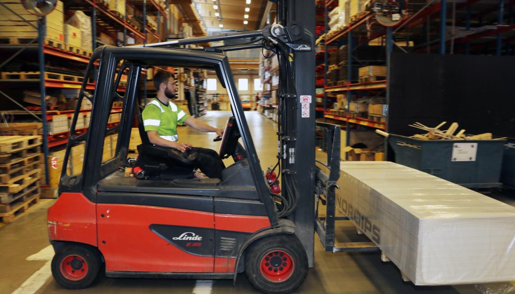 Truckförare som lyfter pall. Foto: Byggmaterialhandlarna