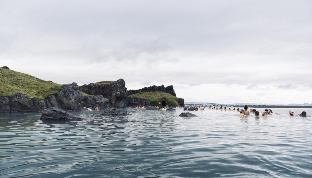 Sky Lagoon på Island. Turister som njuter av ett geotermiskt spa med uppvärmt vatten under en kall dag. Av: Renata Tyburczy