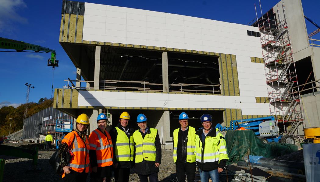 Nu börjar Rimnersbadet i Uddevalla ta form. Maria Jacobsson, Monica Bang Lindberg, Ingemar Samuelsson, Per Bäckström och Christer Hasslebäck med projektledare Anders Emilsson framför bygget av Uddevallas nya simhall. Foto: Uddevalla kommun