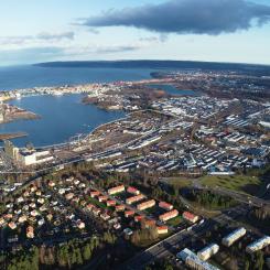 Flygbild över hela Södra Munksjön i Jönköping där Skeppsbron sträcker ut sig längs den södra delen av sjön. Södra Munksjön Utvecklings AB.