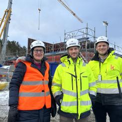 Birgitta Andersson, projektledare samhällsbyggnad, Tobias Lagerwall, projektchef Hemsö och Simon Hagman, projektchef K21 framför bygget av Forshälla-Strands förskola i Råssbyn. Foto: Uddevalla kommun
