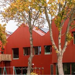 Röd plåt dominerar exteriört byggmaterialet i Mörrums nya F-6 skola med en arkitektur med fokus på hållbarhet och små volymer. Bild: Fojab arkitekter