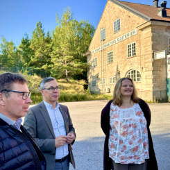 Christer Sundqvist, Johan Söderberg och Marie Bergeås mark- och exploateringschef, framför en av de två "portalbyggnaderna" in till Pumpenområdet. Pressbild: Katrineholms kommun