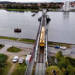 Limfjordsbron i Danmark. Borrningen sker från södra sidan av fjorden och förs vidare under fjordbotten mot norr, mellan de gamla brofundamenten och den nuvarande bron. I det cirka 450 meter långa borrhålet förs ett rör in i ett stycke, varefter elkablarna dras genom röret och kopplas till kontaktledningssystemet. Foto: Banedanmark